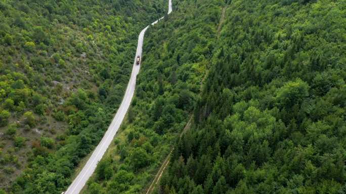 卡车正在运输树干盘山公路绿水青山火车行驶