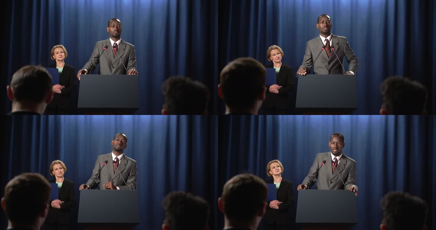 一位身穿灰色西装的非裔美国政治家在辩论中发言时解释了一些事情