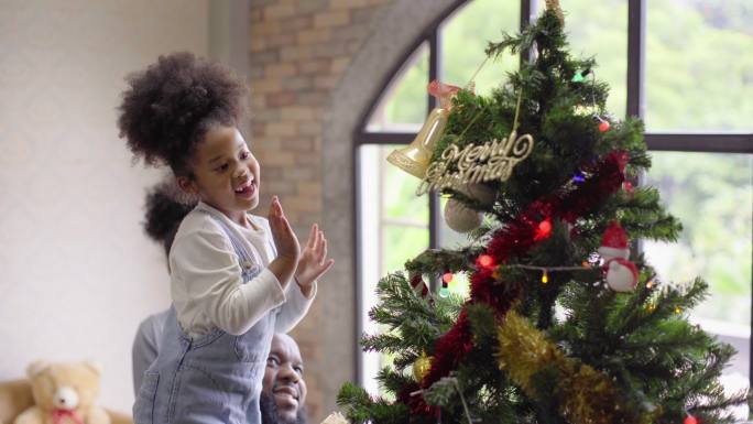 黑人家庭一起在周末活动中加快时间装饰圣诞树，一起享受节日派对