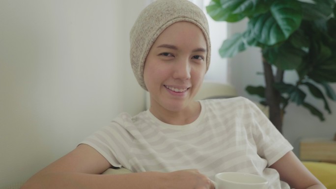 快乐的癌症妇女喝茶。