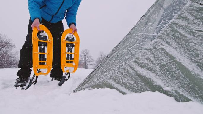 成熟的旅游帐篷露营在冬季山区独自在大自然中。