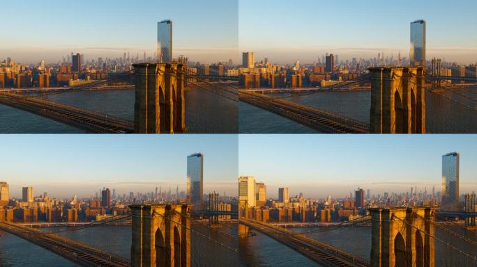 布鲁克林大桥鸟瞰图，远处曼哈顿天际线横跨东河，日出。无人机视频全景环绕和上升摄像机运动。