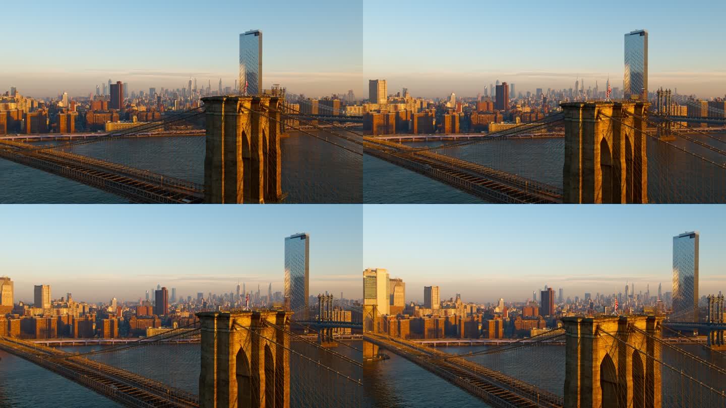 布鲁克林大桥鸟瞰图，远处曼哈顿天际线横跨东河，日出。无人机视频全景环绕和上升摄像机运动。