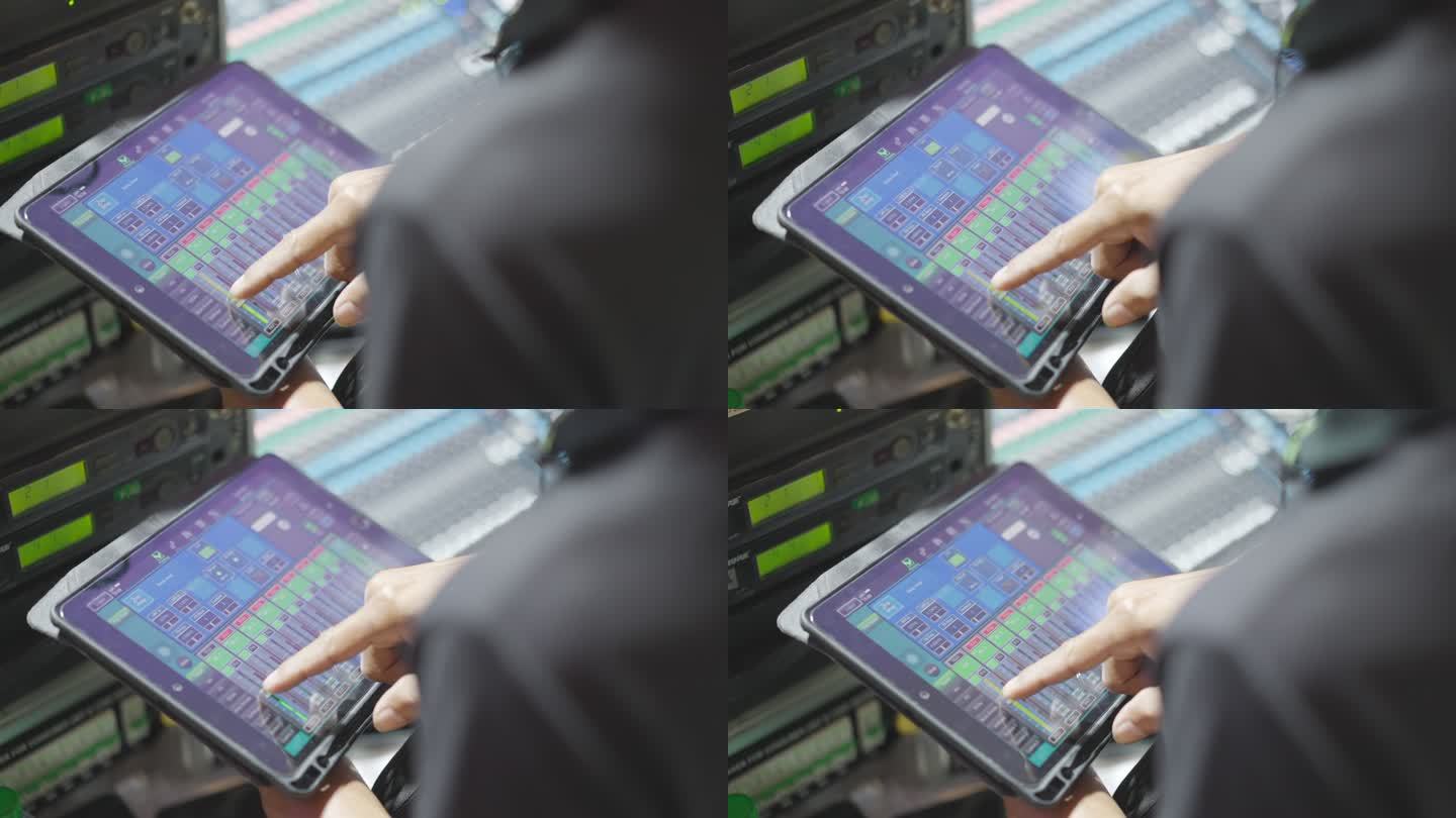 声音工程师在平板电脑上使用音频混音。调整声音。