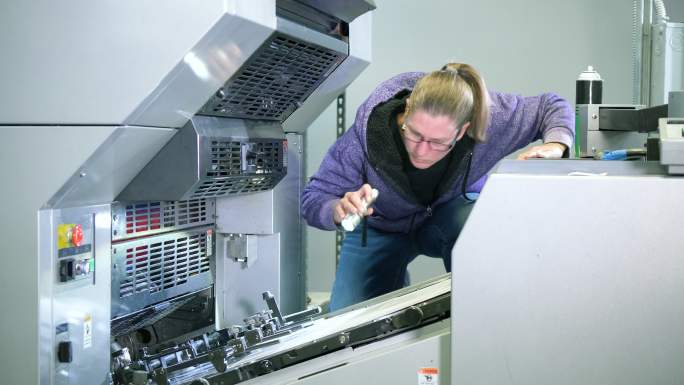 印刷厂的女人试图修理机器
