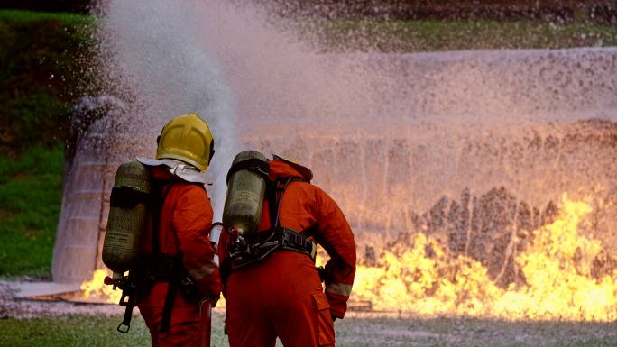 4kUHD消防员使用化学泡沫灭火器扑灭油罐车事故产生的火焰。消防安全灾难事故和公共服务理念。