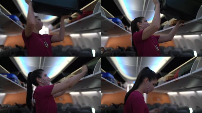 一个戴着口罩的女人把手提箱放在飞机舱的开放日志中