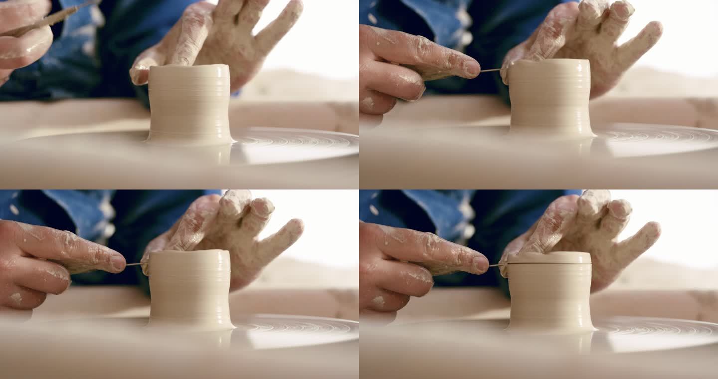 一个人的手在陶轮上模塑湿粘土。男性陶工在他的工作室里雕刻陶瓷艺术。特写一位手工艺师制作手工工艺品作为