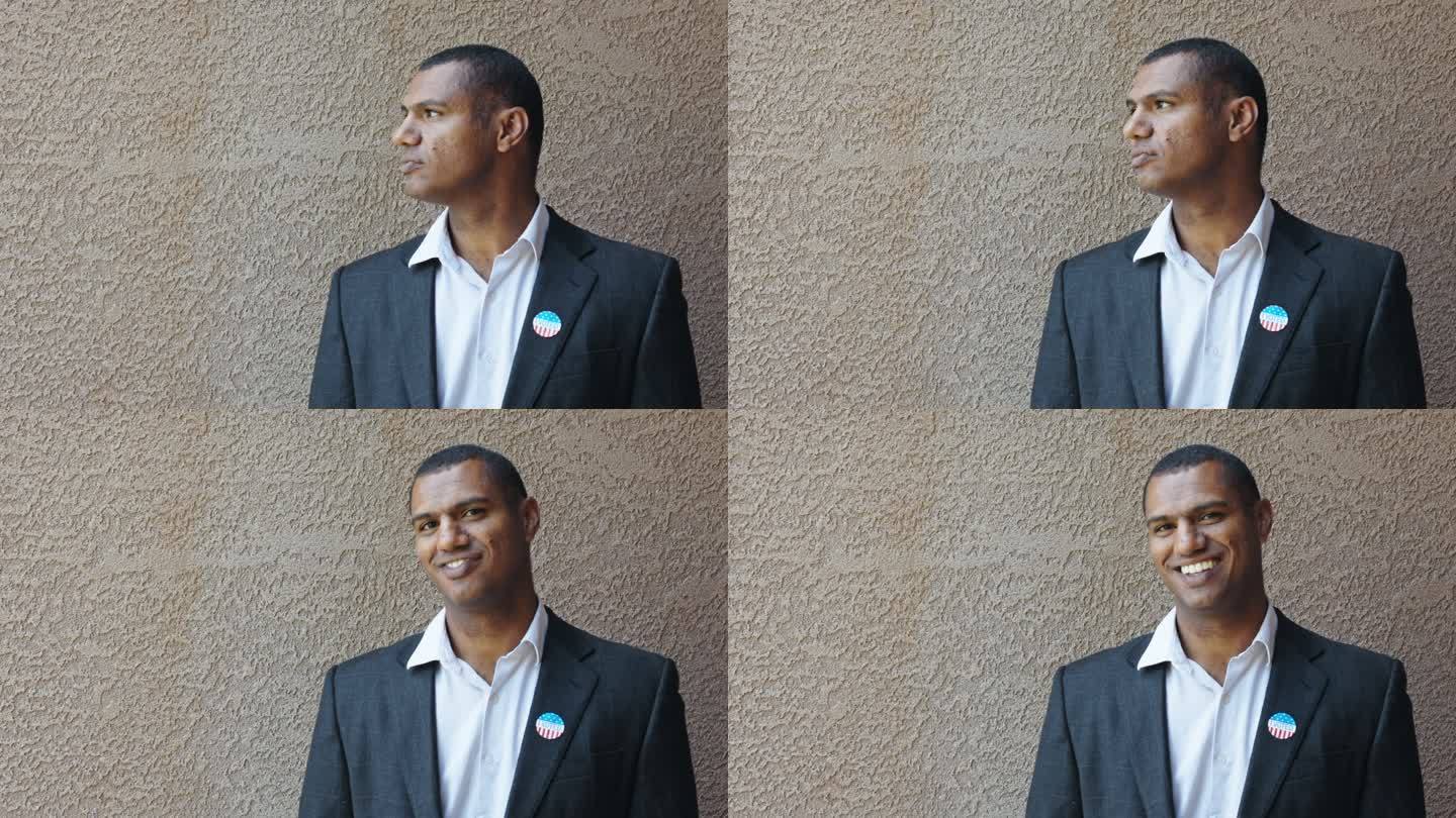 一个英俊自信的非洲裔美国人的肖像，微笑着，看着镜头，完成了他的公民义务，退出了投票