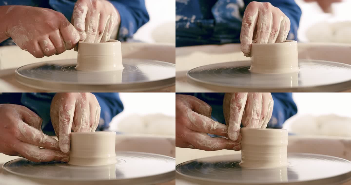 人手在旋转的轮子上雕刻一个陶罐的特写镜头，带有复制空间。放大一个陶工的技能，在车间里练习他的手艺。柔
