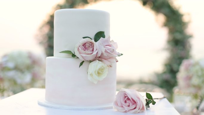 美丽的婚礼蛋糕装饰着鲜花和白色的色调。