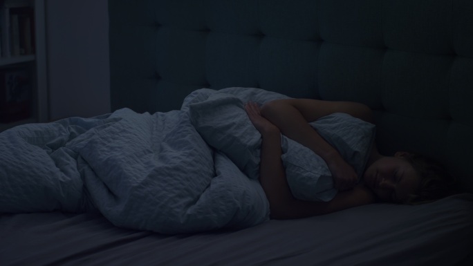 睡在床上的女人因失眠而无法入睡