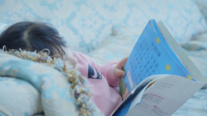 小女孩读书阅读指读躺在沙发看书眼睛发育