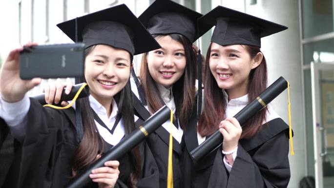 东亚毕业-穿着毕业礼服和帽子的女性