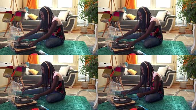 在家听乙烯基唱片坐在地毯上的黑人女性欣赏