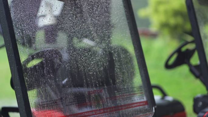 下雨天停在高尔夫球场的空红色高尔夫球车