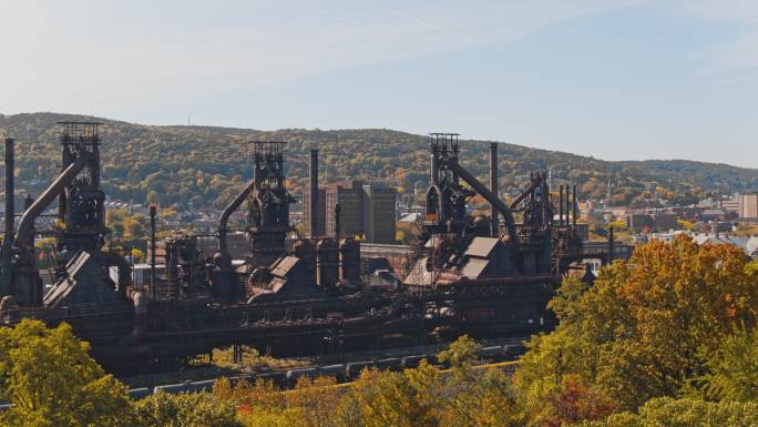 SteelStacks-宾夕法尼亚州伯利恒的历史性钢铁计划。无人机拍摄的树木后摇摄的空中视频。