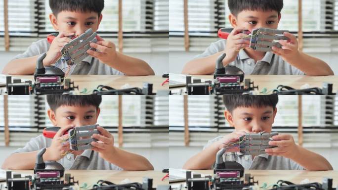 男孩在家里用电脑构建和编程，并将机器人手臂作为学校科学项目。他对自己的工作很满意。教育、儿童、技术、