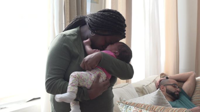 母亲让新生儿入睡黑人母亲抱着婴儿哄孩子男