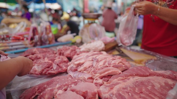 泰国的亚洲生鲜市场，他们正在购买猪肉。