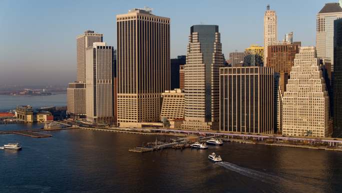 从东河鸟瞰曼哈顿市中心，水上的士和船只抵达和离开11号码头-华尔街。用静态摄像机拍摄无人机视频。