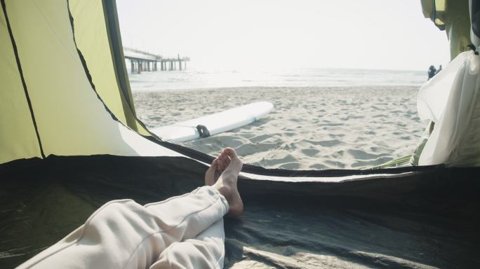 一个男人在海滩上的帐篷里放松
