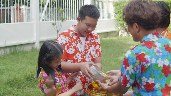孩子们把水倒在尊敬的长辈的手上，用泰国的颂克兰书法祈求祝福