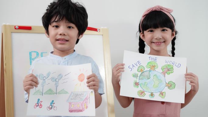 两个亚洲小学生，男孩和女孩，在全班同学面前展示并拿着他们的画作，主题是拯救世界，脸上挂着微笑和快乐。