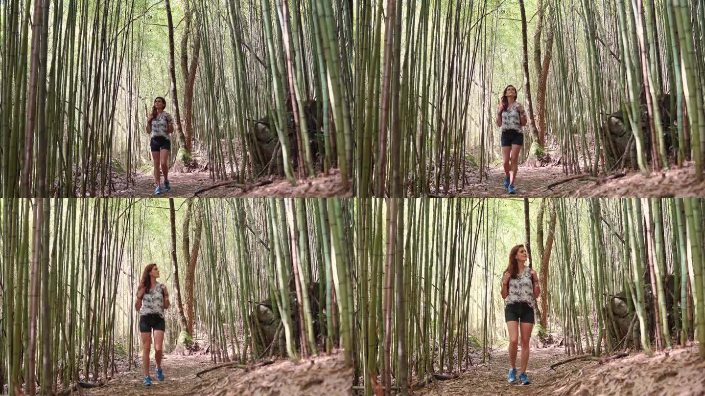 年轻女子在竹林中的小路上散步