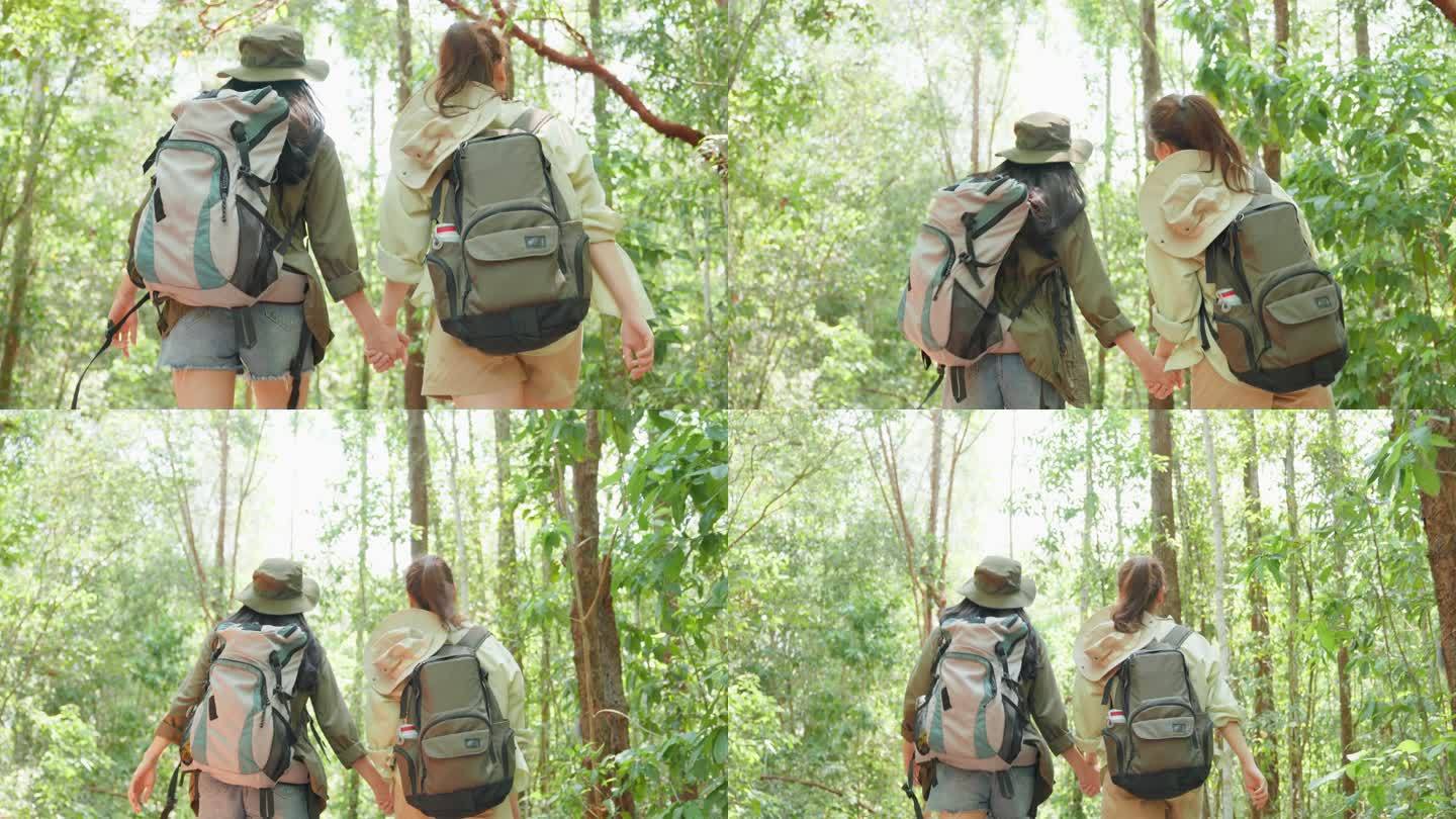 亚洲美女两位背包客一起在森林野外旅行。吸引人的年轻女性朋友在夏季度假旅行中快乐地散步和探索自然森林。