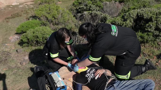 两名女性医护人员协助伤者。