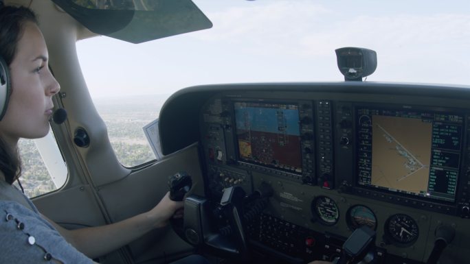 年轻成年女飞行员驾驶单引擎飞机，以最佳爬升速度爬升，并将多功能飞行显示调整到地图页面