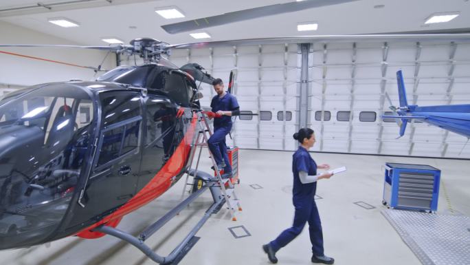 CS女机修工将检查表交给直升机上的航空机修工