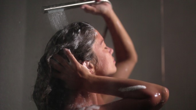 女人在淋浴间洗头。