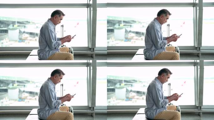 亚洲资深男子在机场使用智能手机