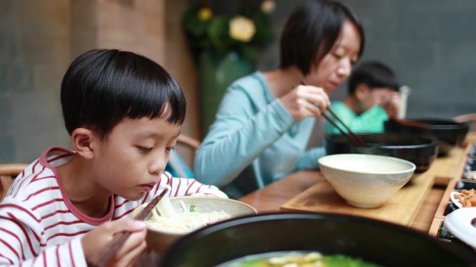 男孩用筷子吃米粉现代生活吃早餐