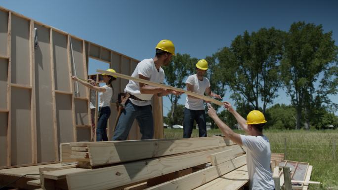 阳光明媚的一天，一群志愿者在慈善建筑工地上辛勤工作