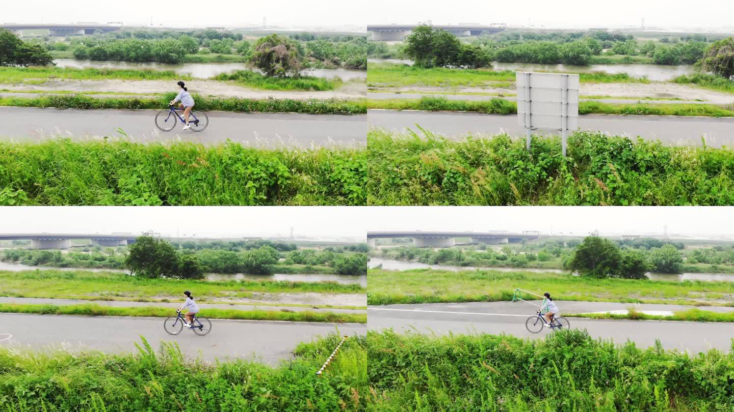 一名女子在河边的路上骑自行车