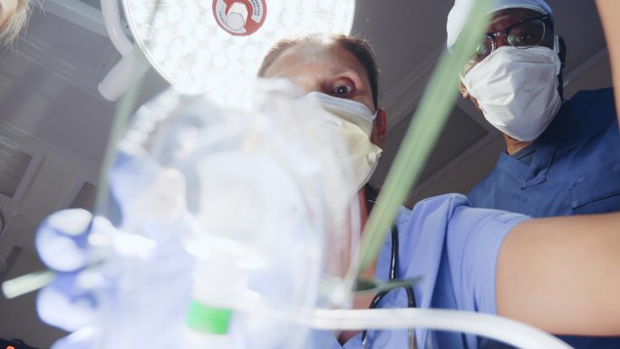 医疗专业人员将氧气面罩放在看不见的患者身上