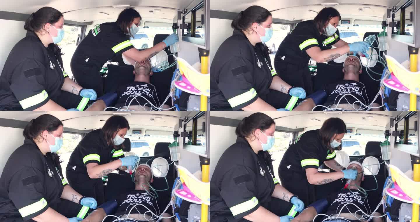 两名女性护理人员在救护车上协助一名男性患者。