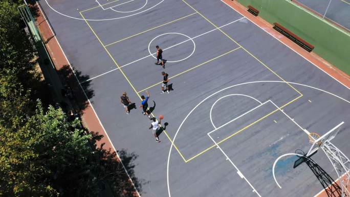头顶上一群面目全非的男子打完篮球后走在一起。年轻人在上面运动