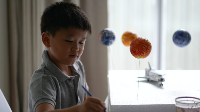 亚洲男孩用水彩画地球。生态创意概念与环境问题