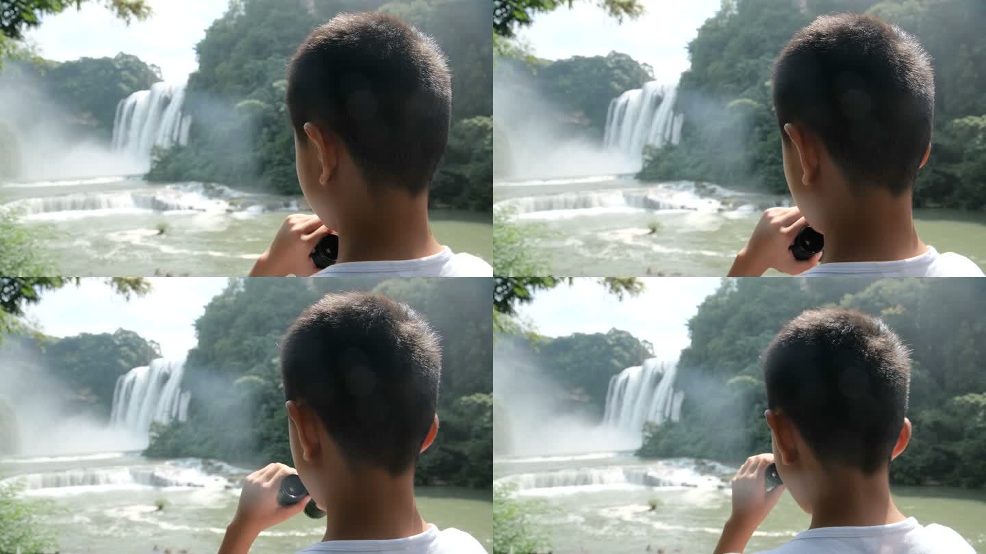 男孩用望远镜看瀑布