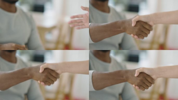 在办公室里，特写的商人黑人非洲裔与商人白人白人一起握手。商业、庆祝、成功、团队合作、握手：非白人概念