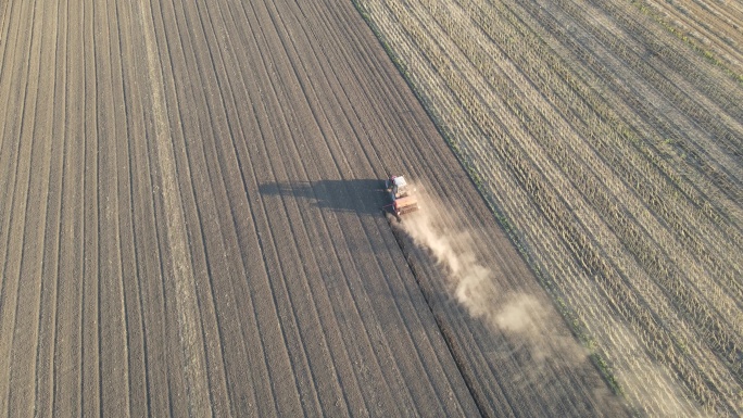 拖拉机耕作多尘田地的俯视图