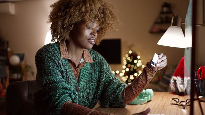 一名女子在网上购买圣诞礼物并输入信用卡信息