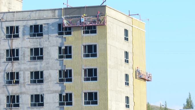 楼房建筑工地工人在做墙体保温层施工