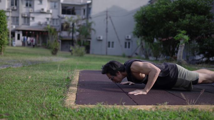 亚洲中国肌肉男在户外锻炼。平板式触地、俯卧撑、深蹲跳、哑铃曲