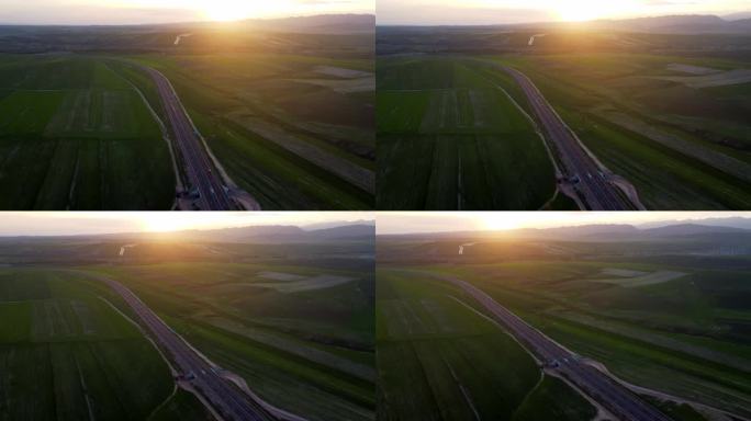 夕阳下航拍穿过麦田的高速公路
