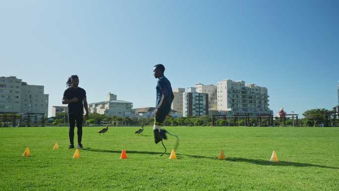 教练指导男性截肢运动员在阳光公园进行运动训练